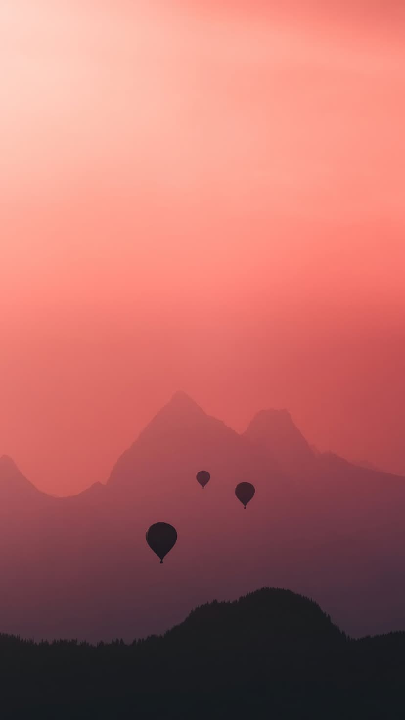 Hot air balloon silhouettes float above misty mountain ranges under a vibrant red and pink sunrise sky.