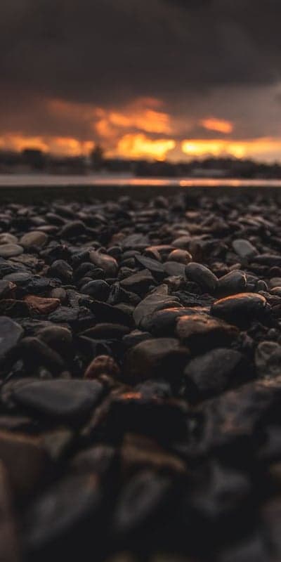 Pebble Shore at Dusk - Fiery Sky Over Smooth Stones