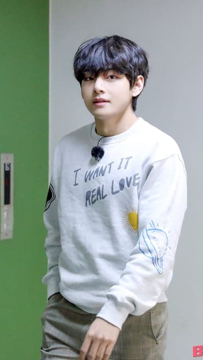 V from BTS wears a sweatshirt with "I Want It Real Love"