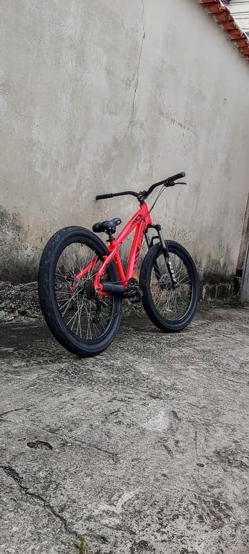 Red Mountain Bike Leaning Against Textured Wall