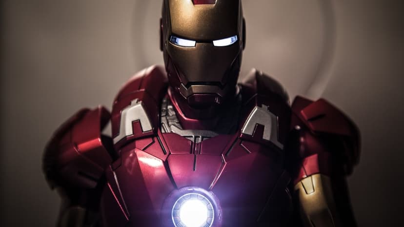 Iron Man figurine displays metallic red and gold armor with glowing arc reactor details in a dynamic hero pose.