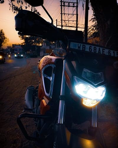 Motorcycle Headlights Shine at Sunset on a Road