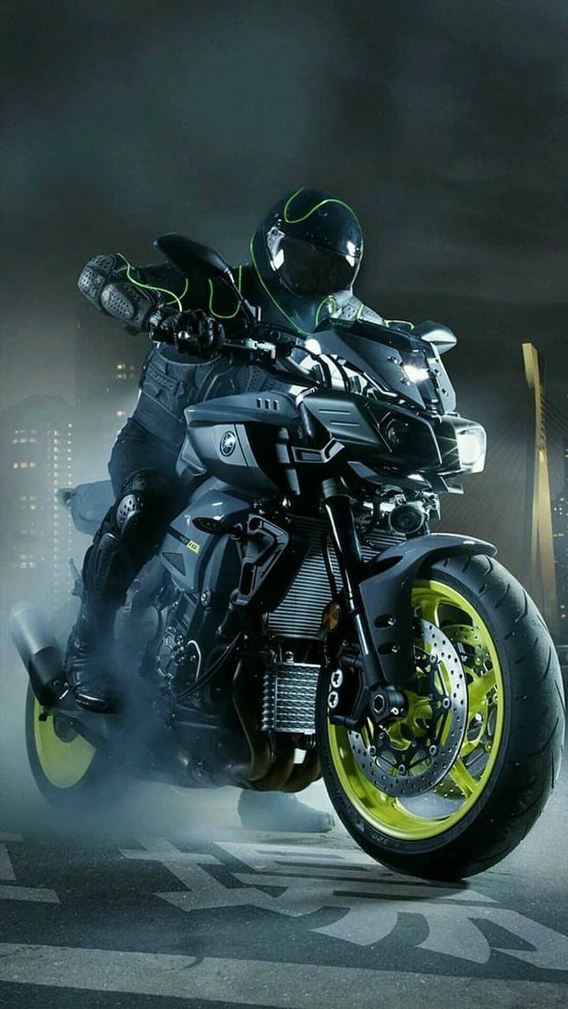 Motorcycle rider in full gear leans on a Yamaha bike with glowing green neon accents amid swirling tire smoke.