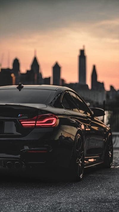 Dark BMW M4 Silhouette at Sunset Cityscape Phone Wallpaper