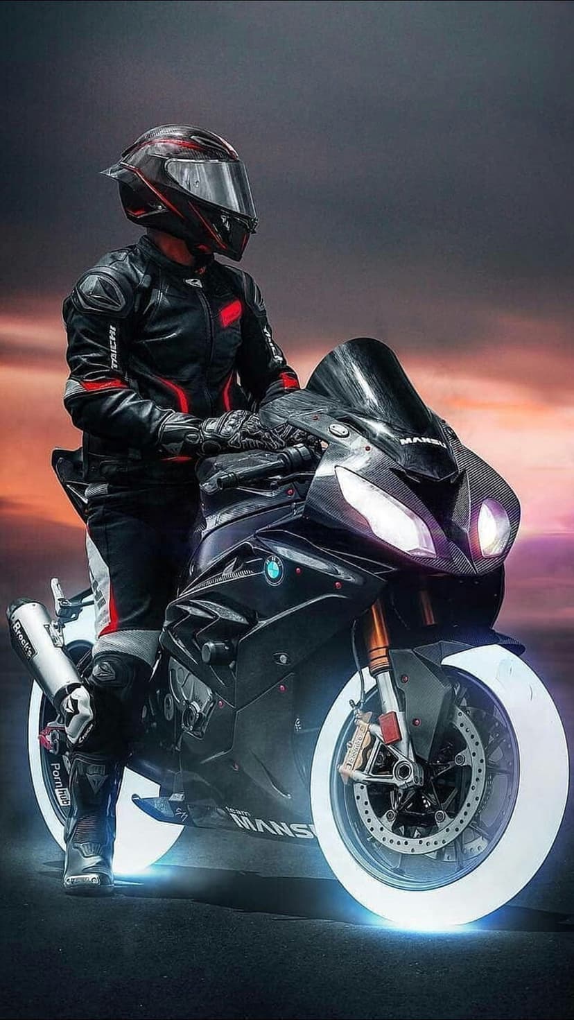 Motorcyclist on a black sportbike with glowing white tires and headlights under a warm sunset sky.