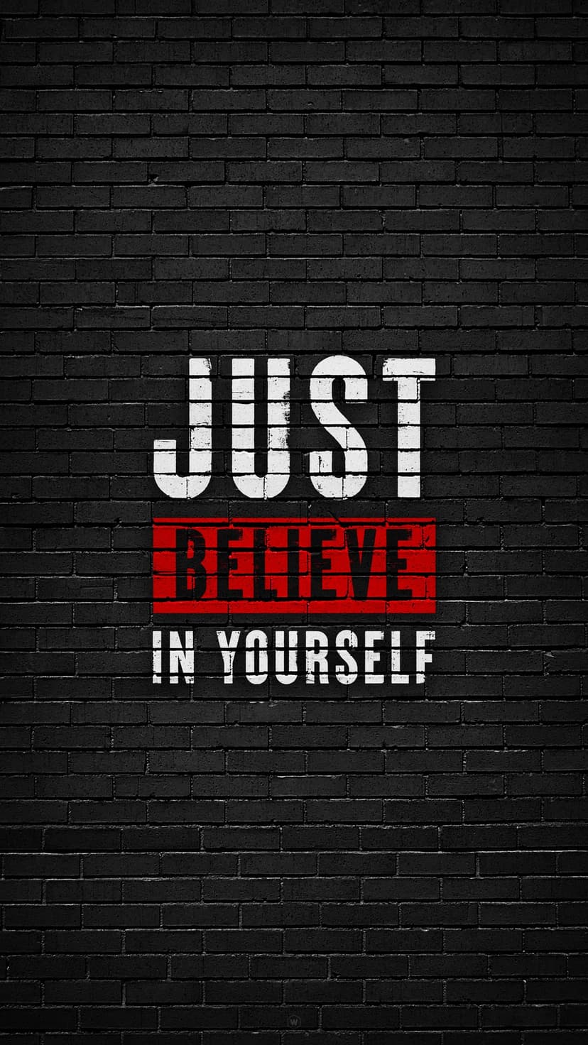 Just Believe In Yourself text in white and red spray paint on a dark, textured black brick wall backdrop.