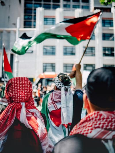 Protesters waving Palestinian flags in a street protest