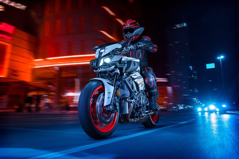 Motorcyclist on a Yamaha MT-10 riding through a neon-lit city at night with blue and red motion blur.