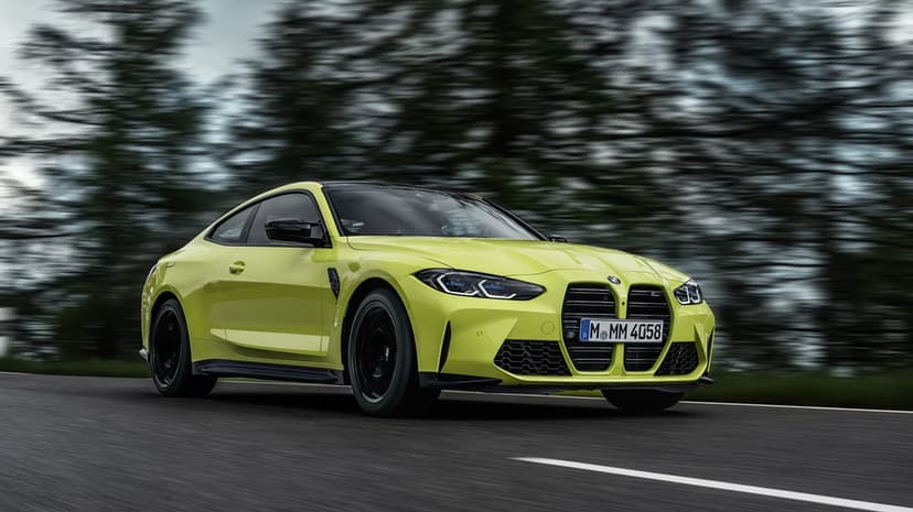 Sao Paulo Yellow BMW M4 G82 Coupe driving on a road with motion blurred trees in a landscape wallpaper view.