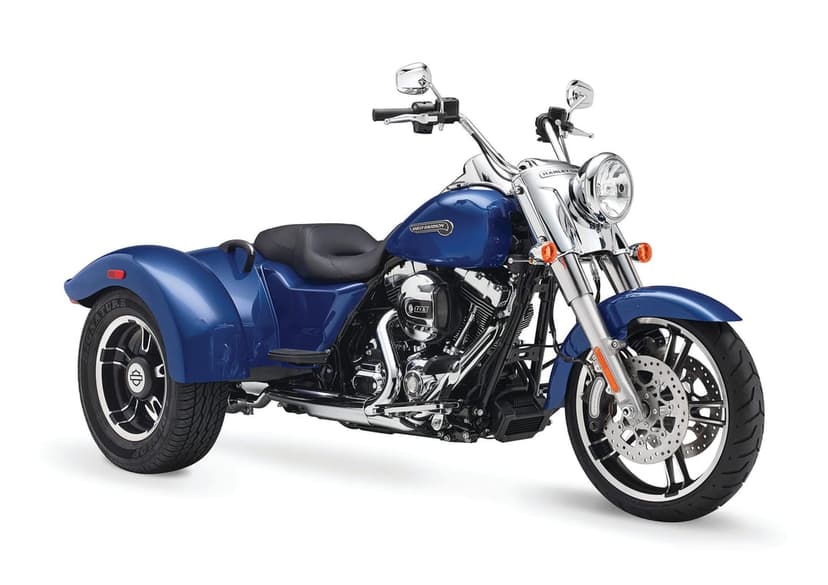 Blue Harley-Davidson three-wheel motorcycle with chrome engine details and black leather seat on white background.