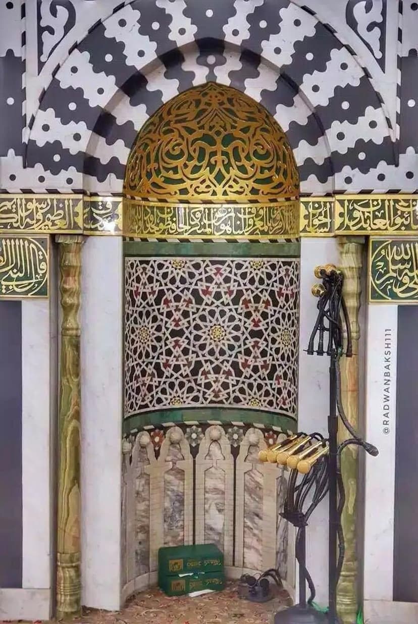 Golden Arabic calligraphy and intricate geometric tile patterns decorate a circular mosque dome ceiling.