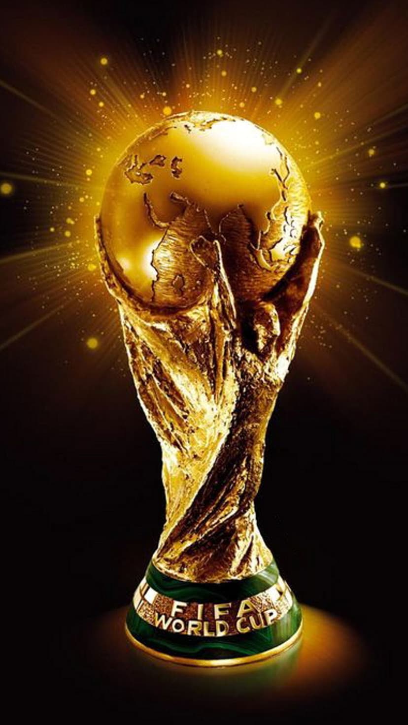 FIFA World Cup trophy held by sculpted hands, glowing with golden light and sparkling particles on a dark base.