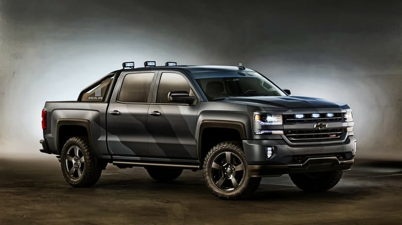 Chevrolet Silverado Special Ops truck with matte camouflage wrap, LED lights, and off-road tires in a dark studio.