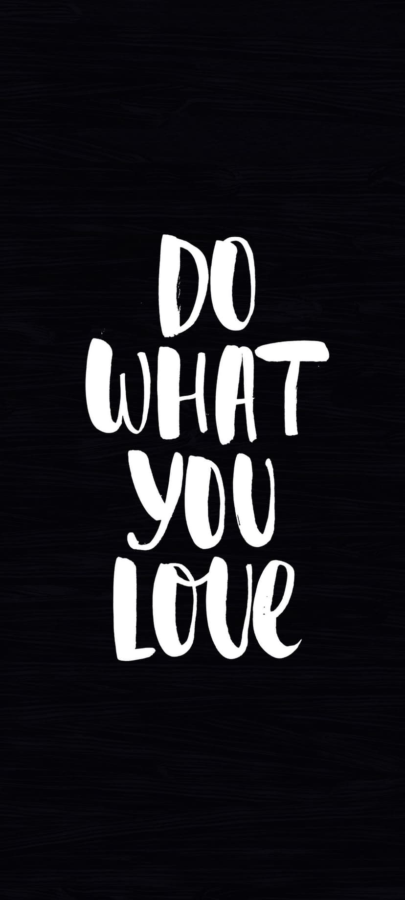 Handwritten white text reading Do What You Love centered on a dark black surface with subtle grain texture.
