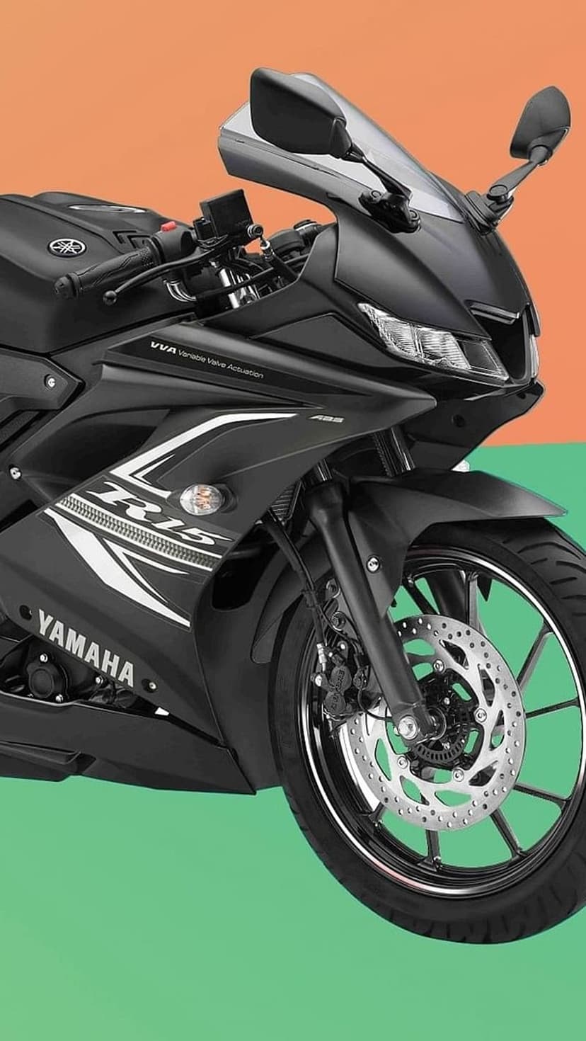 Yamaha R15 sportbike in matte black features sharp LED headlights and front disc brakes on a colorful background.