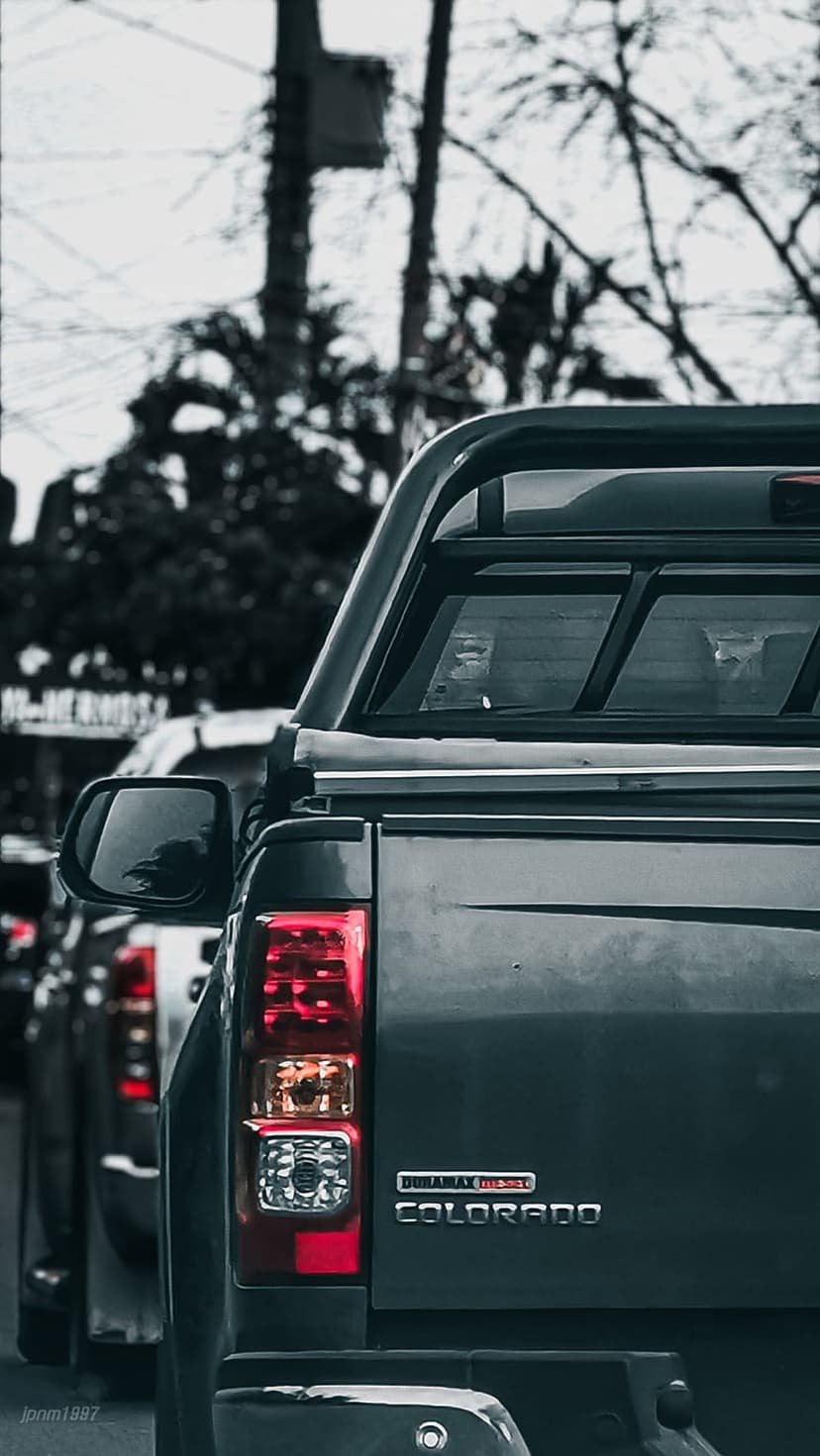 Dark grey Chevrolet Colorado truck rear showing the red taillight, chrome badging, and Duramax Diesel emblem.