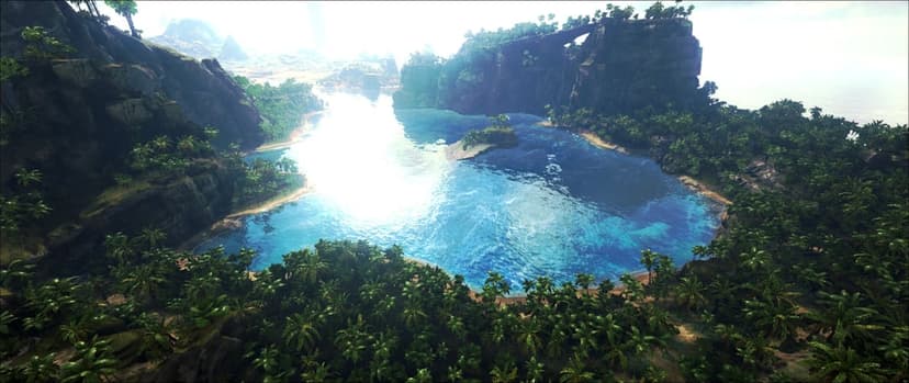 Aerial view of a tropical lagoon with bright sun glinting on blue water surrounded by lush palm trees and cliffs.