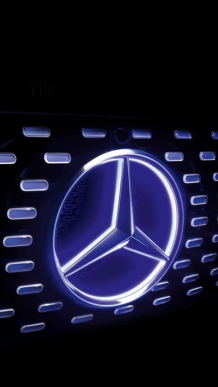 Mercedes-Benz star emblem glowing blue on a dark horizontal slatted vehicle grille in a close-up shot.