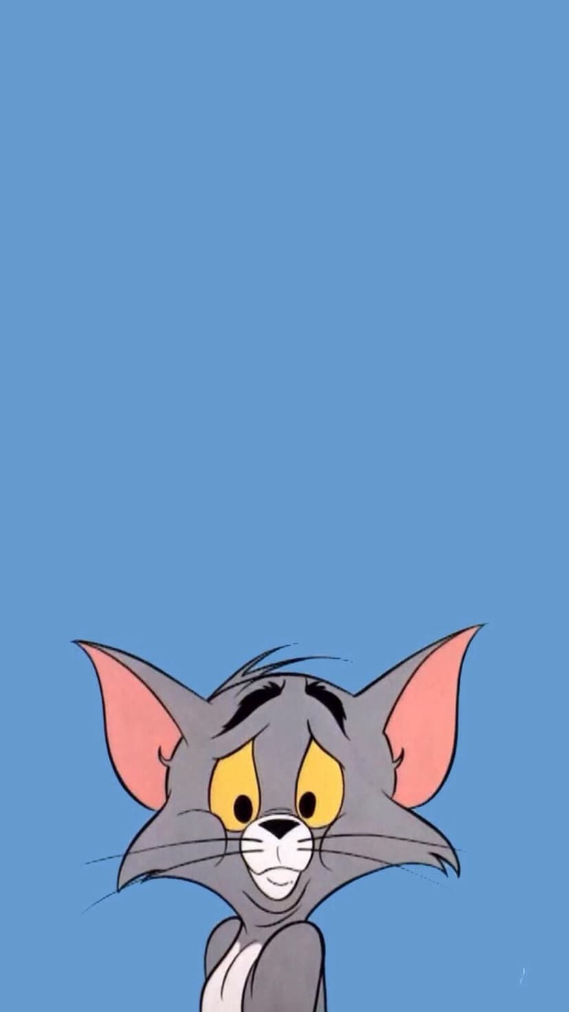 Tom Cat peeking from the bottom edge with sad yellow eyes and drooping eyebrows against a solid blue background.