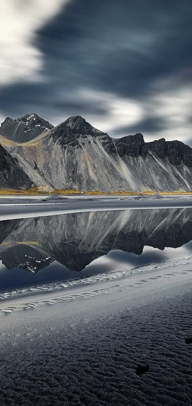 Coastal Peaks Reflected Under Streaked Skies