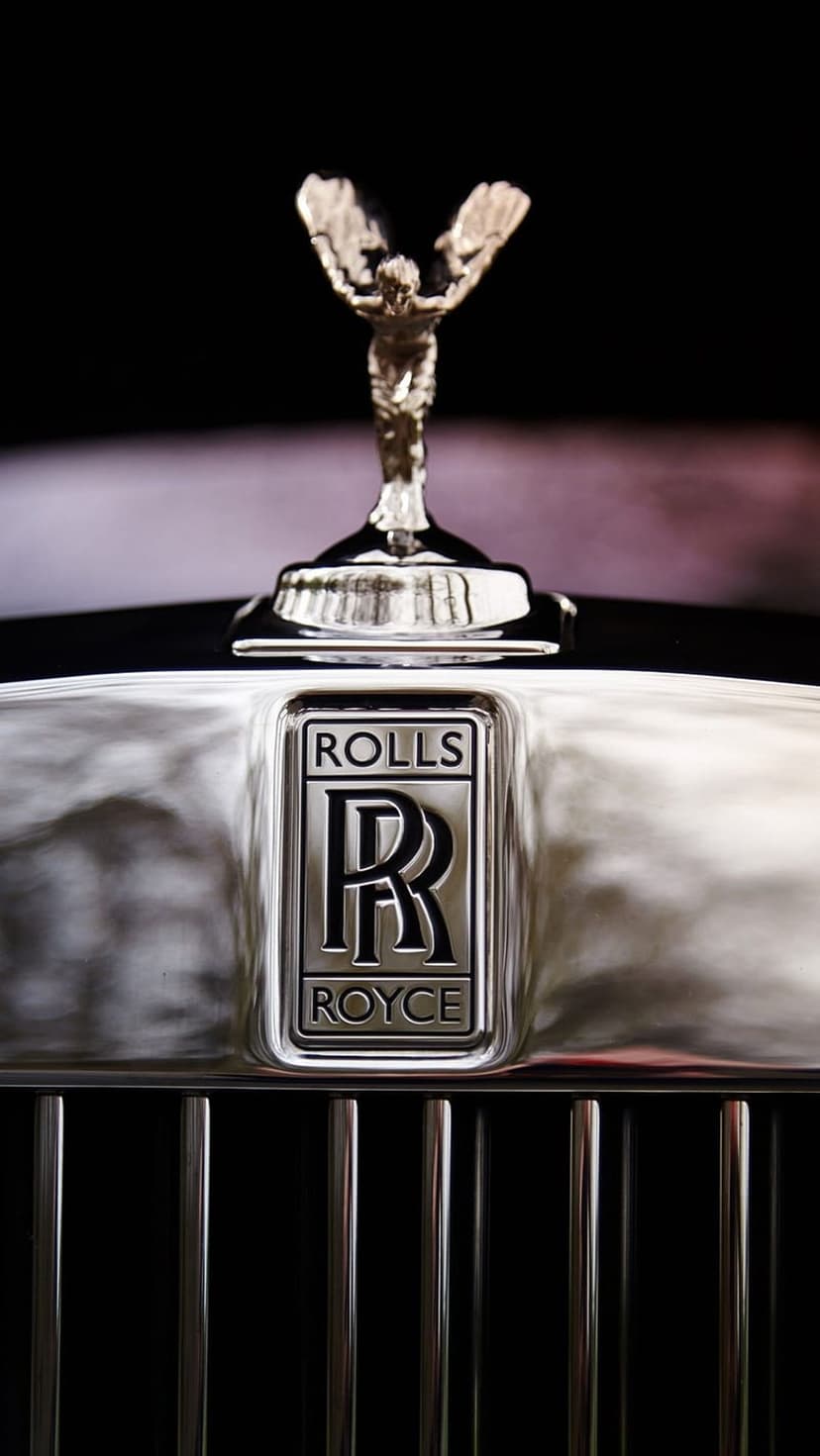 Spirit of Ecstasy figurine and polished vertical chrome grille slats showing reflective silver metal surfaces.