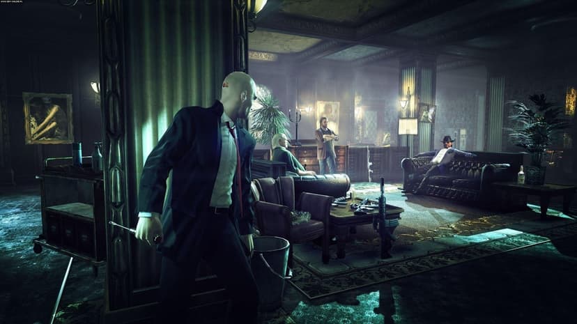 Agent 47 in a black suit peeks around a pillar in a dark room towards men sitting on a leather sofa.