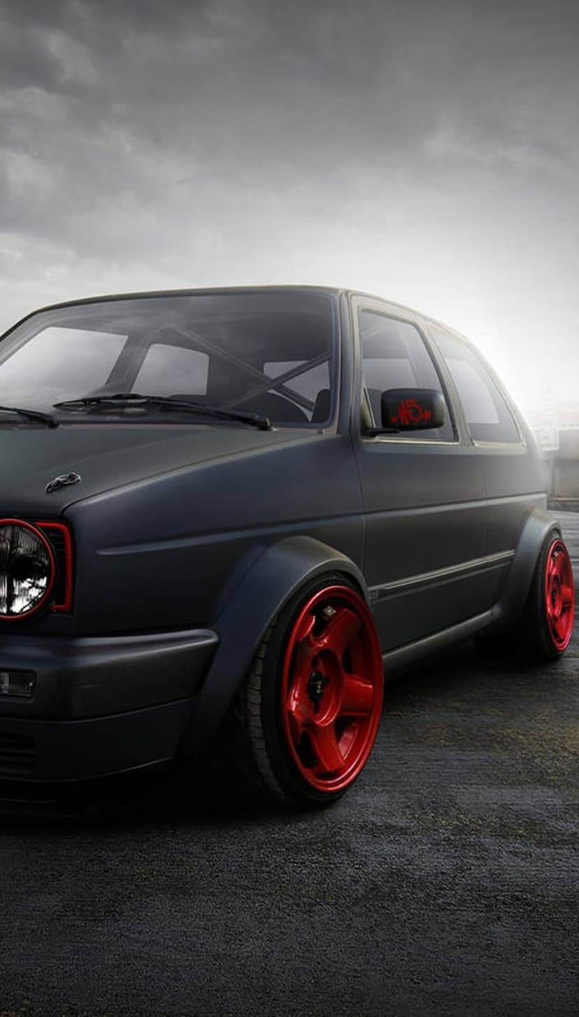 Matte black VW Golf MK2 with red aftermarket wheels, a widebody kit, and a roll cage on a vertical screen.