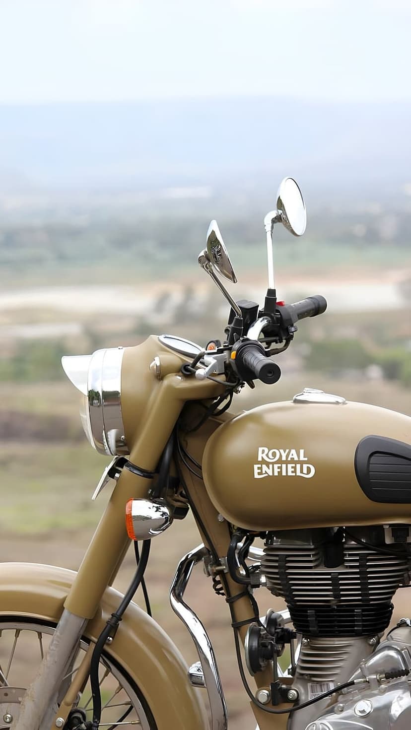 Royal Enfield motorcycle with desert camouflage fuel tank, chrome engine, and handlebars in an outdoor setting.