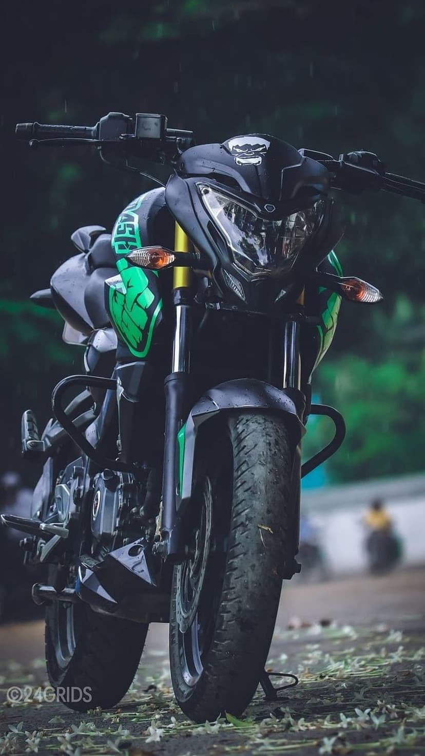 Green and black sportbike front fairing on wet pavement with white flowers during a moody rain shower.