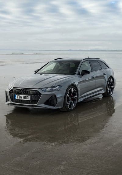 Grey Audi RS6 Avant parked on a wet beach