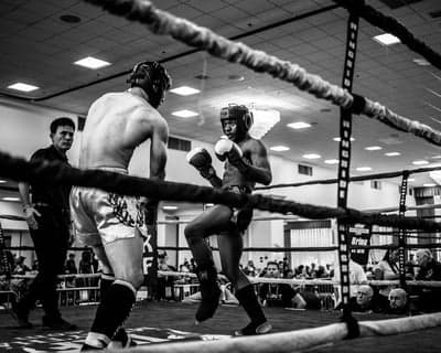 Muay Thai fighters in black and white boxing ring