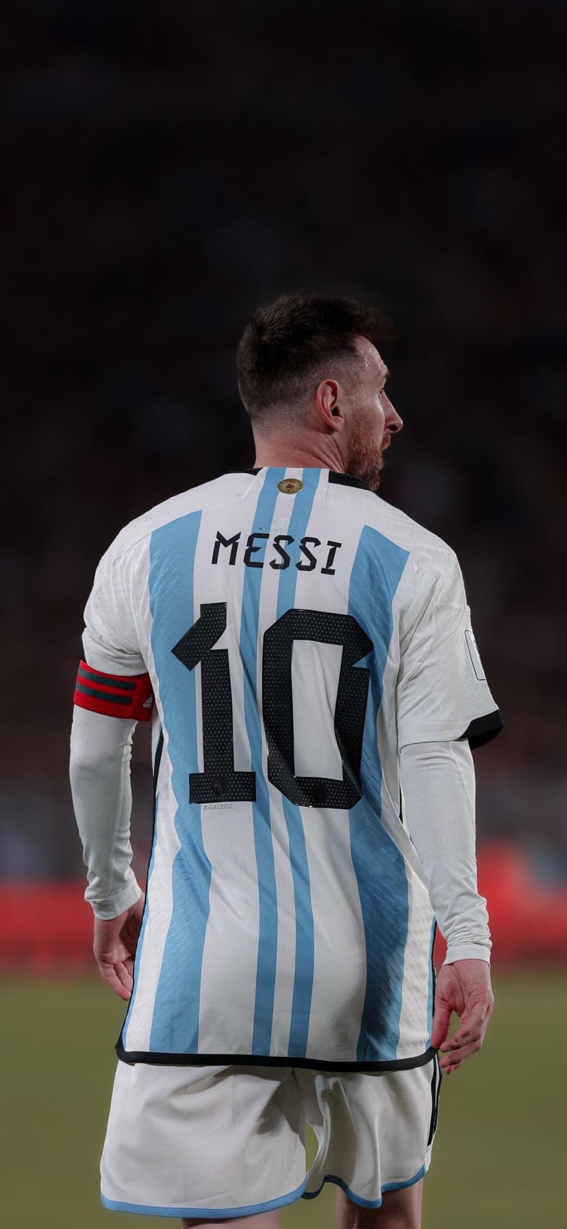 Lionel Messi seen from behind wearing the blue and white striped Argentina jersey with number ten on his back.