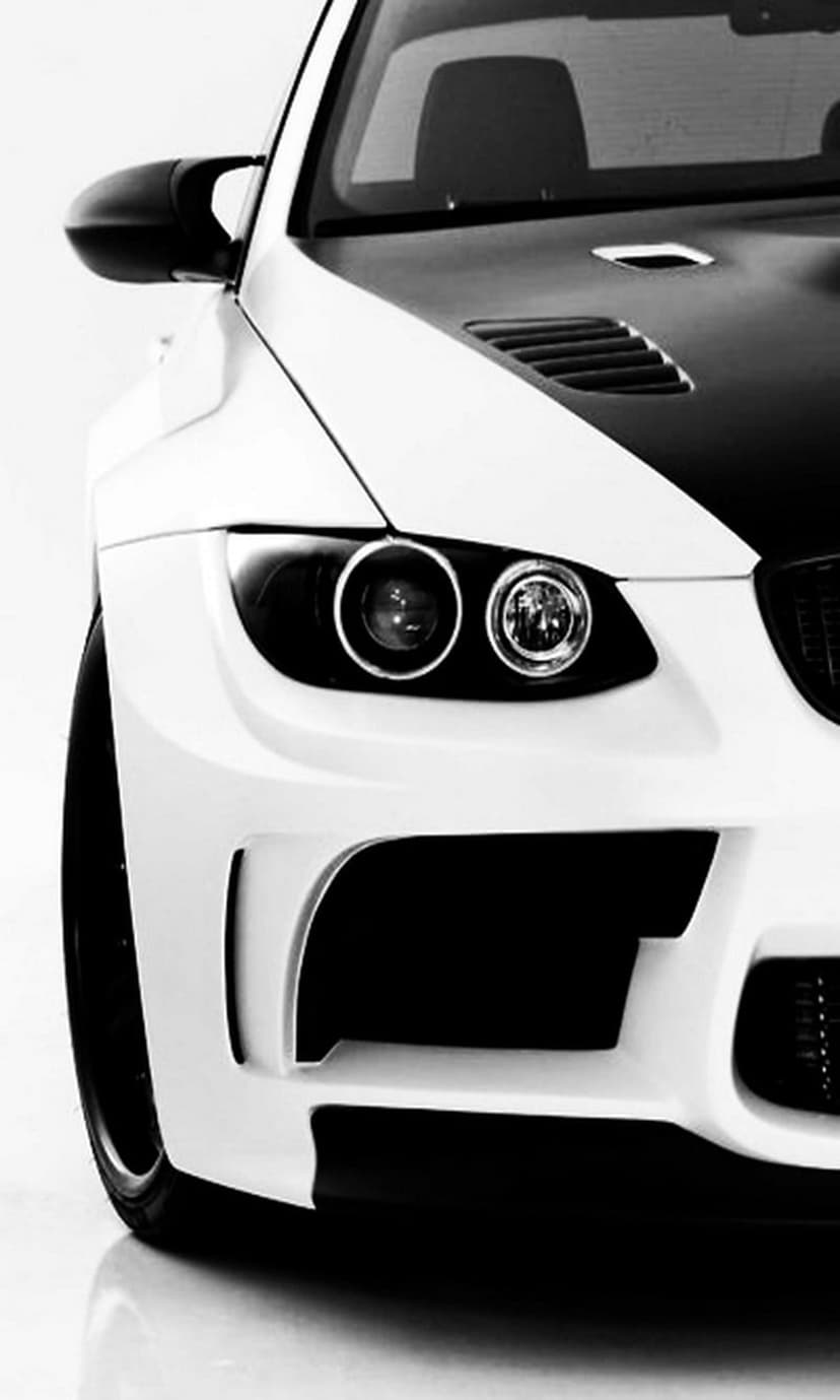 High-performance sports car front with aggressive headlights and ventilated hood in a sharp monochrome close-up.