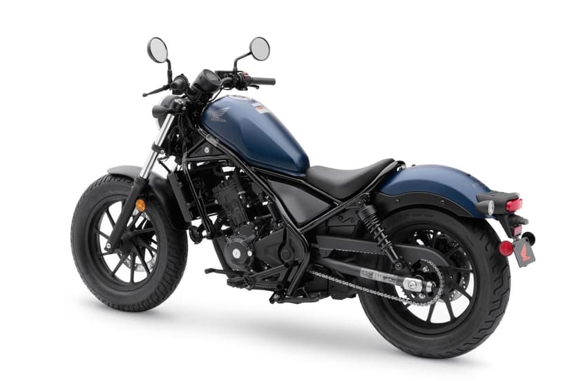 Matte blue Honda Rebel motorcycle features a black frame and engine against a bright white studio background.