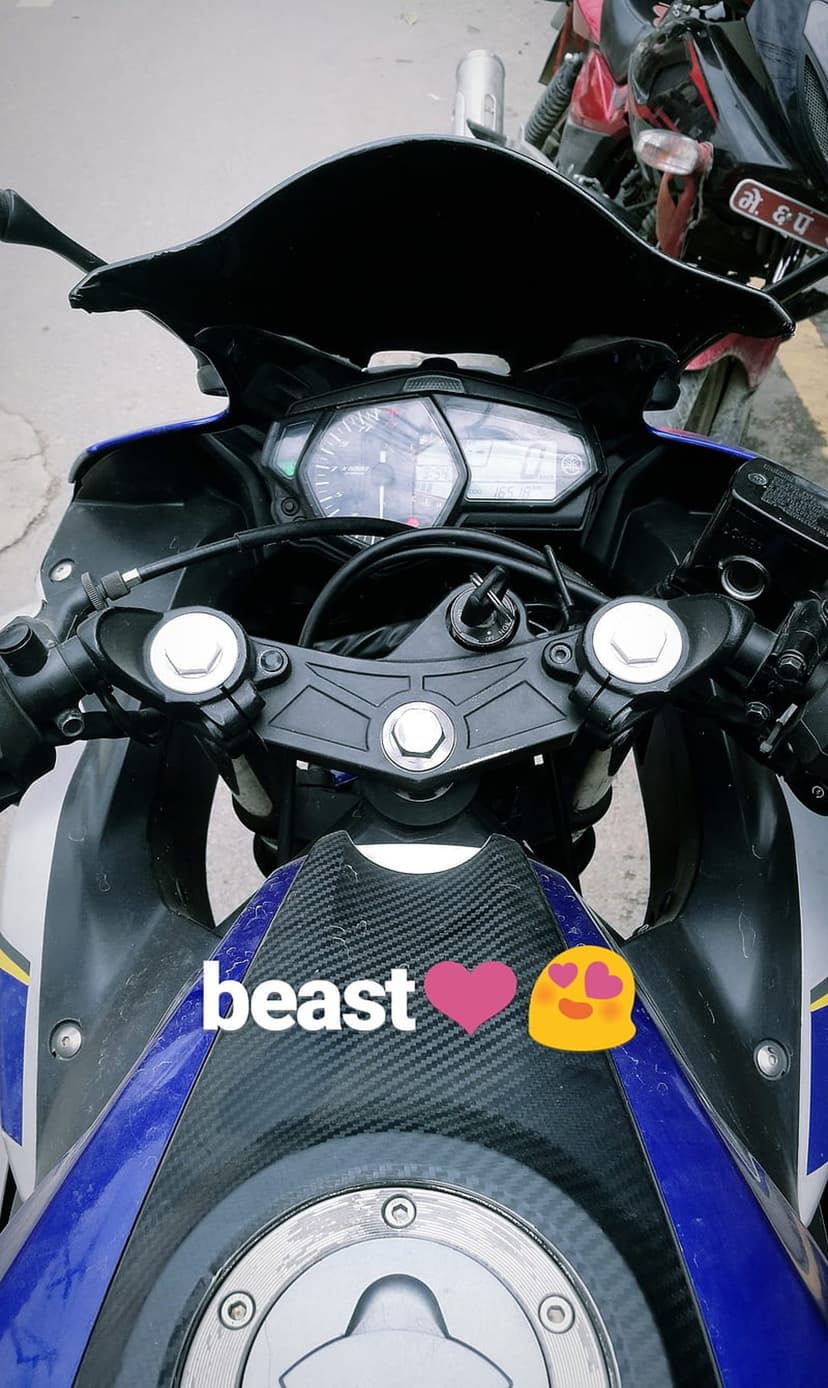 Sportbike handlebars with a beast sticker and analog gauges viewed from a first-person rider perspective.