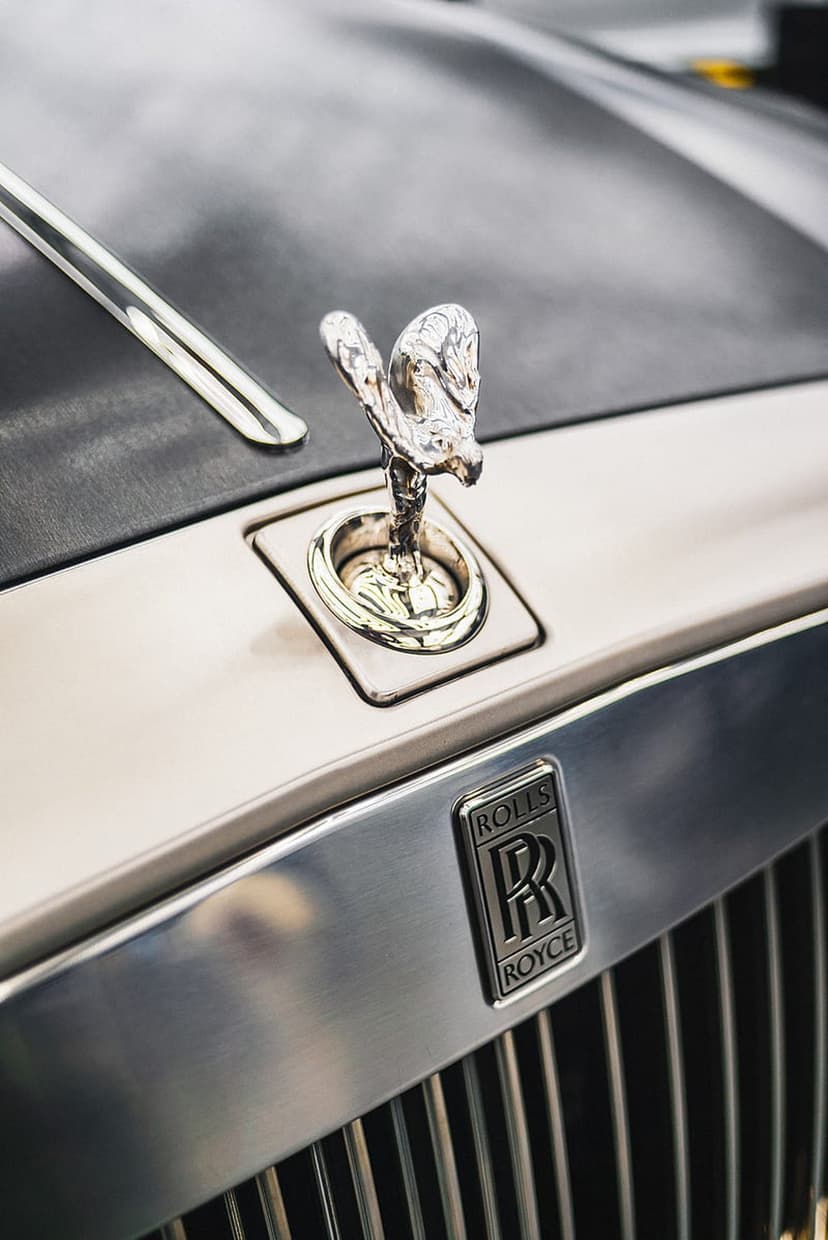 Silver Spirit of Ecstasy figurine with outstretched arms atop a polished chrome Rolls-Royce radiator grille.