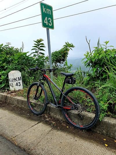 Bicycle rests by Kilometer 43 marker on scenic mountain road