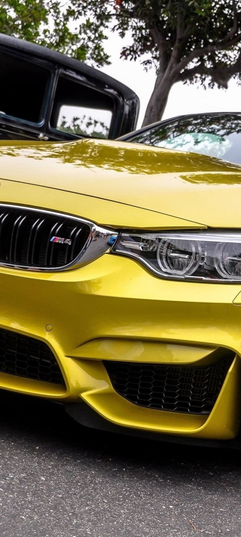 Yellow BMW M4 front grille and LED headlight with metallic reflections and a sharp, aggressive bumper design.