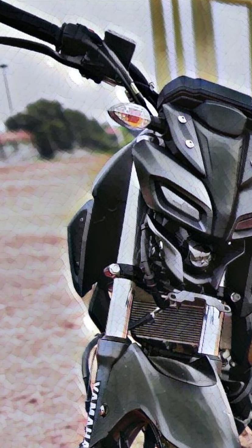 Yamaha MT-15 motorcycle front view featuring distinctive LED headlights and handlebars against a blurred background.