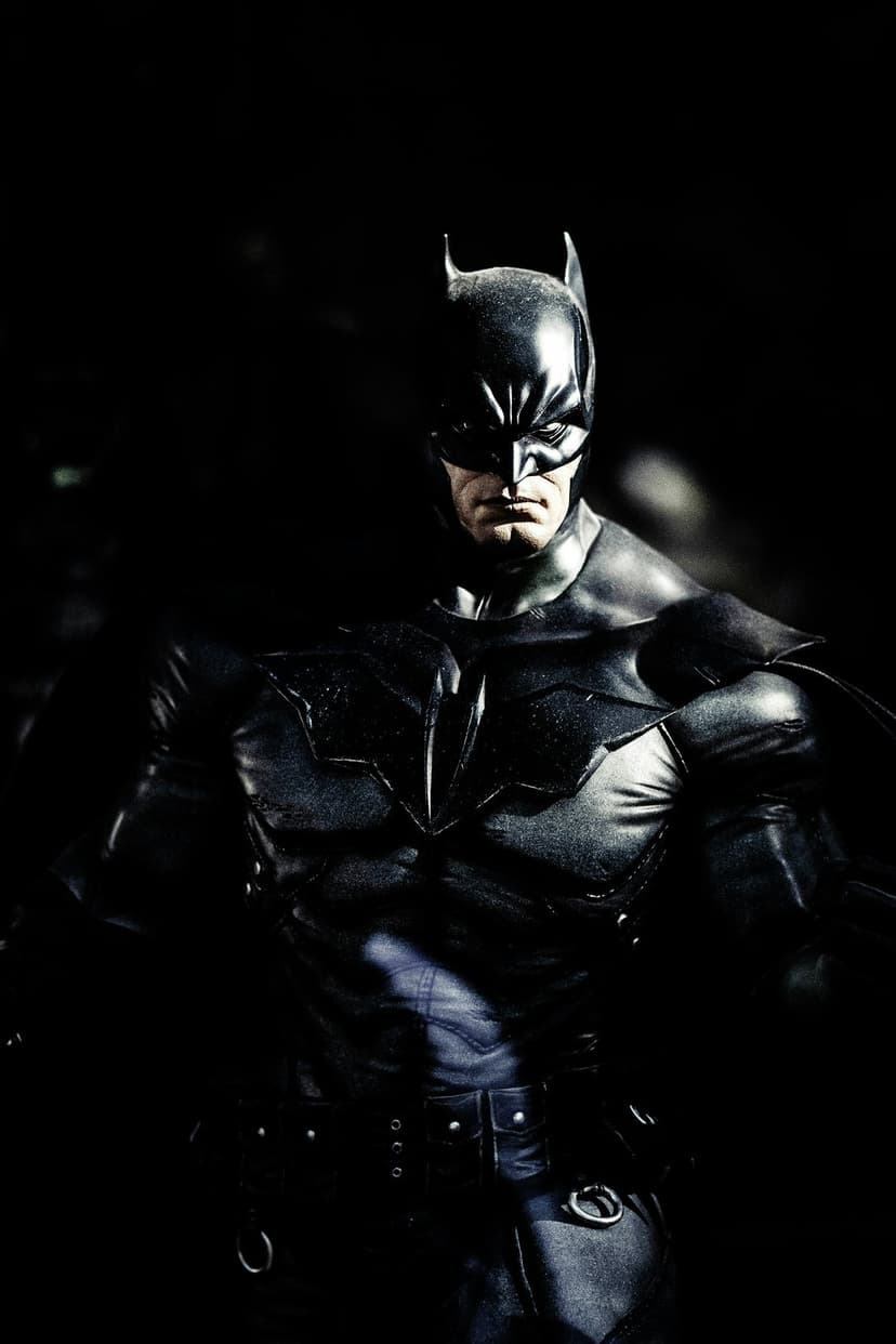 Batman armored chest plate featuring a matte black bat symbol, illuminated by sharp side lighting and deep shadows.