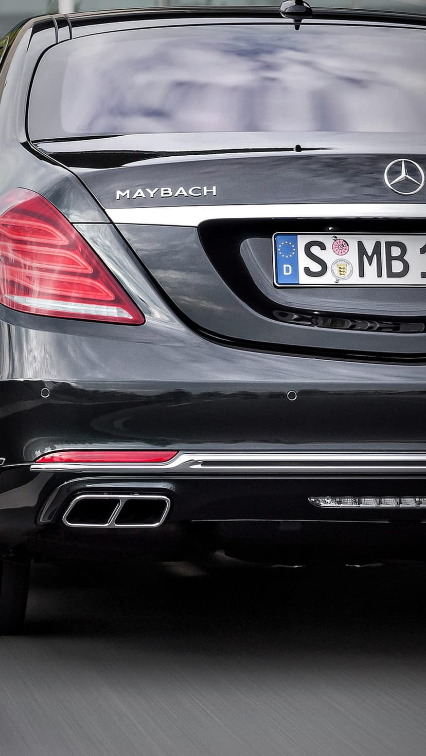Black Maybach S-Class rear bumper featuring dual chrome exhaust outlets, silver emblem, and German license plate.