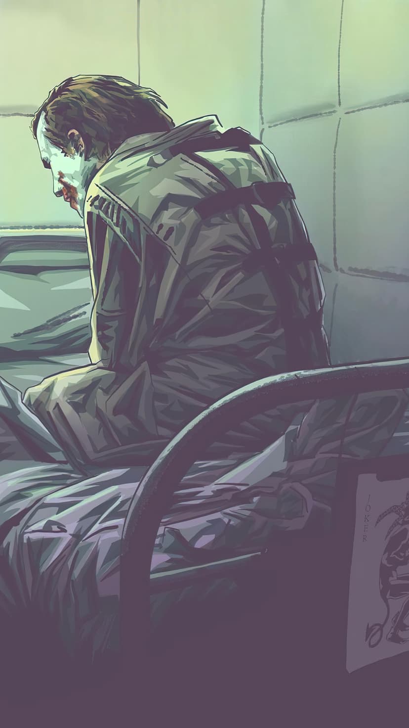 Joker wearing a white straitjacket sits in a dark padded cell looking down with a somber expression.
