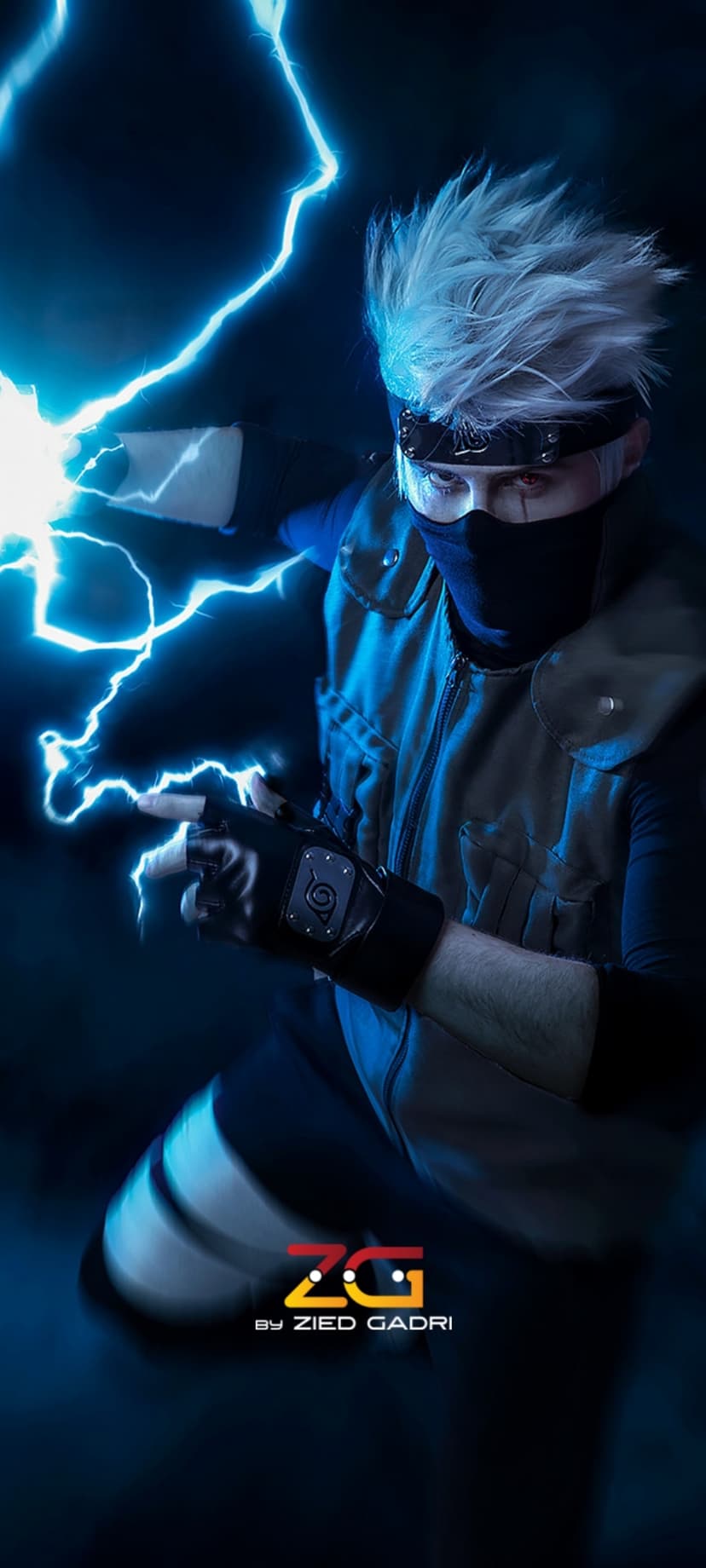 Kakashi Hatake cosplayer in a tactical vest holds glowing blue lightning against a dark, moody backdrop.