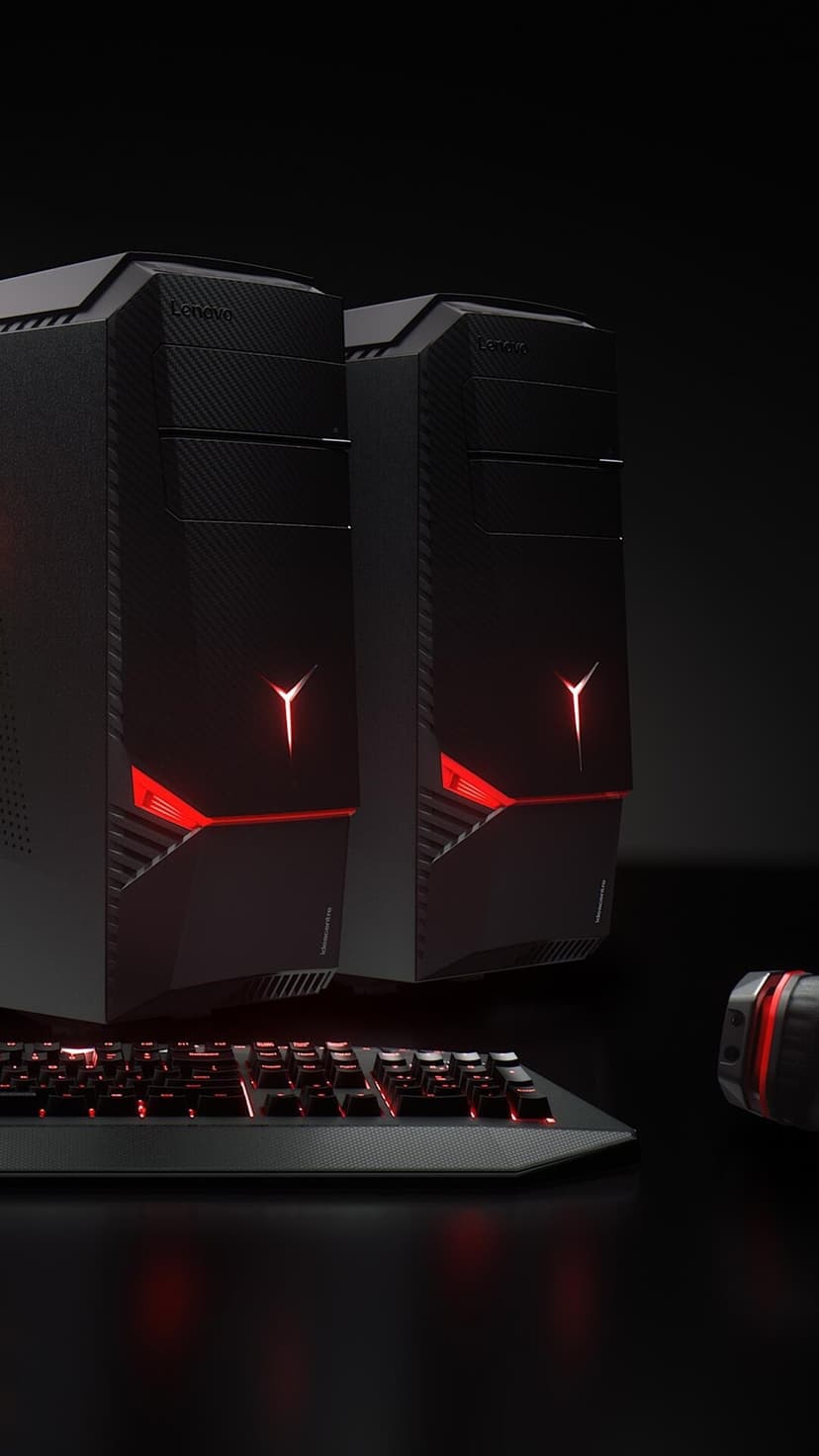 Lenovo Legion gaming desktops with glowing red logos and a backlit mechanical keyboard against a dark background.