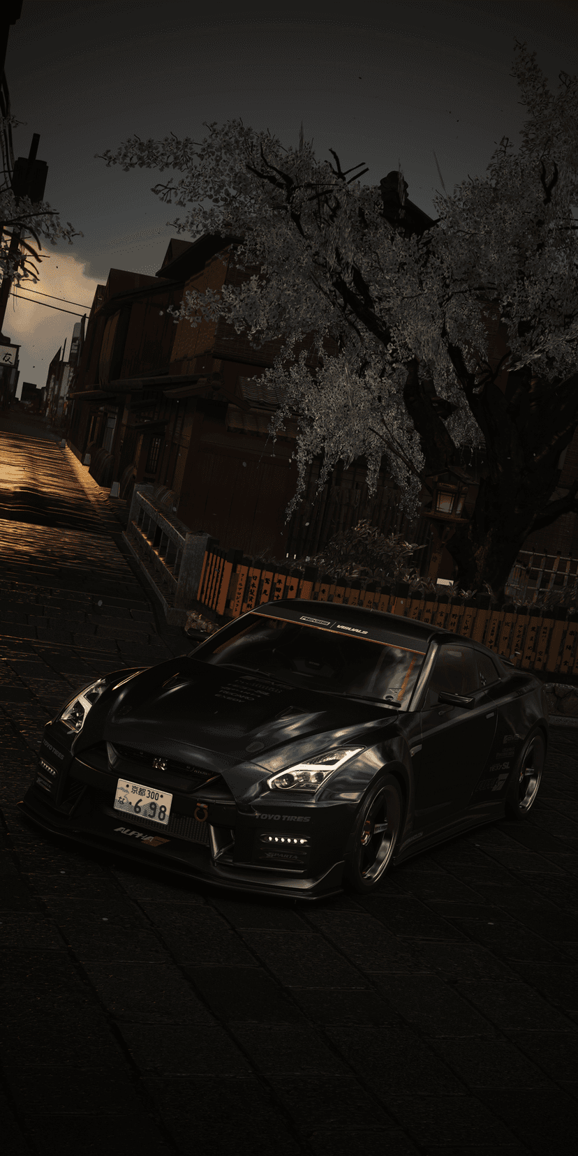 Nissan GT-R sports car parked on a cobblestone street under white cherry blossoms during a blue hour twilight.