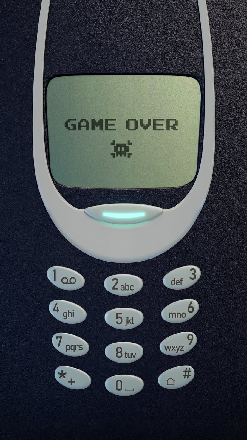 Classic Nokia phone screen displays pixelated game over text and a retro alien graphic on a green LCD display.
