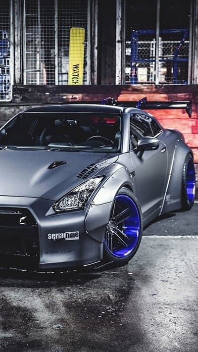Matte grey Nissan GT-R with widebody kit and blue rims