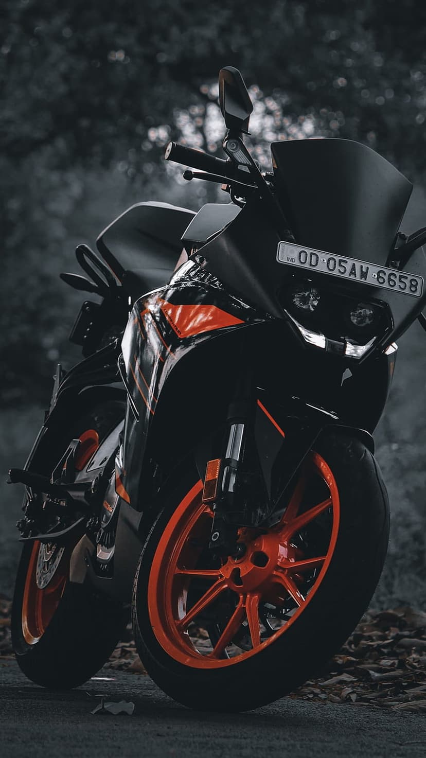 KTM RC 390 motorcycle with orange rims and black bodywork parked outdoors under moody natural light.