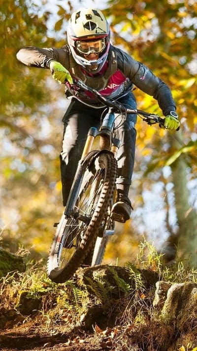 Mountain biker races down a steep, wooded trail