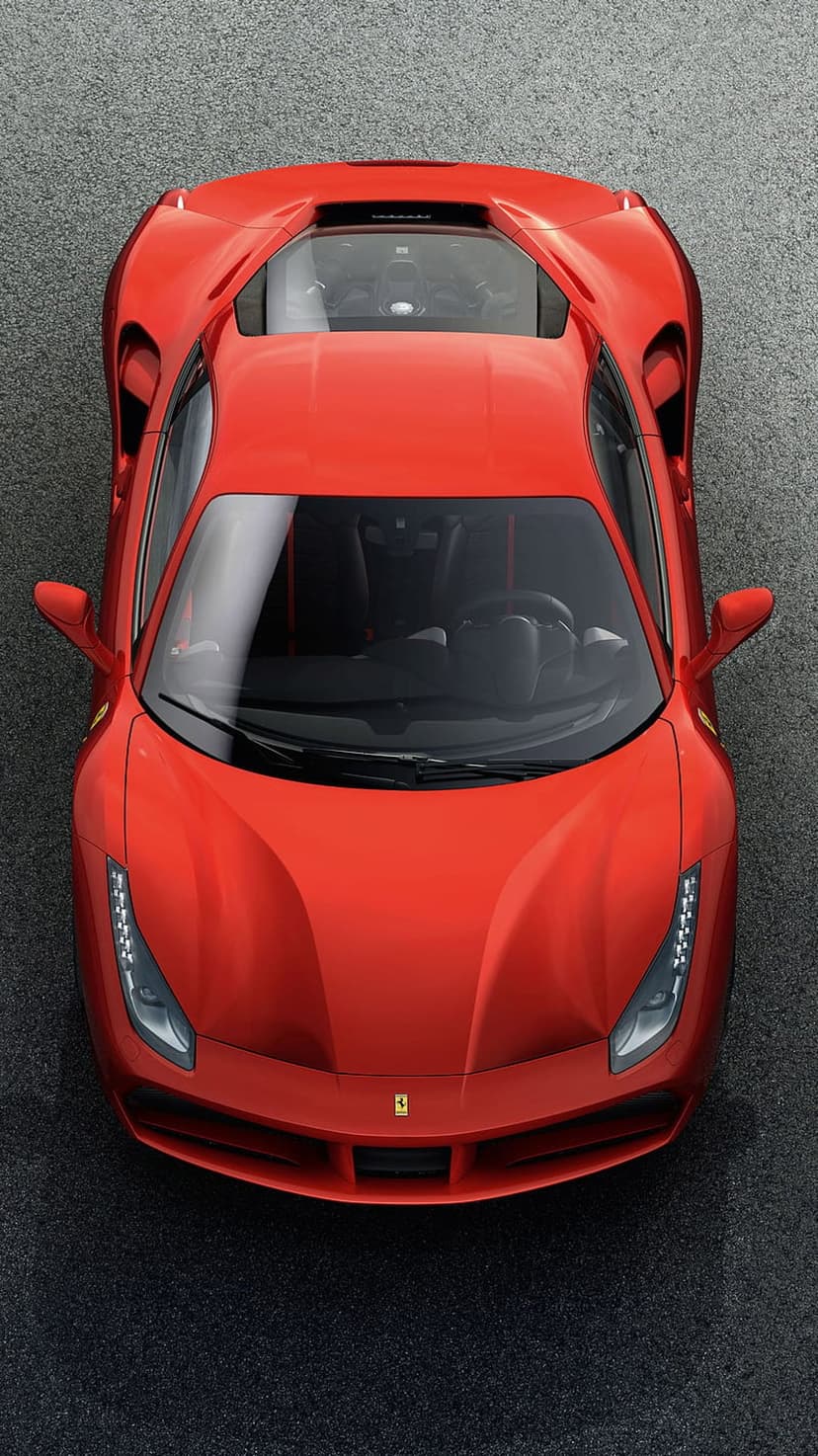 Red Ferrari 488 GTB parked on dark asphalt seen from an aerial top-down angle, highlighting its sleek body shape.